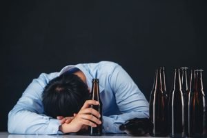 Alcoholic Asian Man With Lot Of Beer Bottles