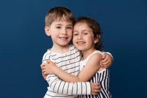 smiley little kids holding each other 300x200 - ¿Cuándo se pueden pedir medidas urgentes de protección al menor?