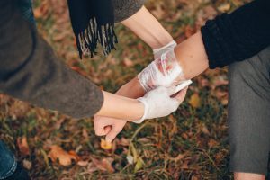 Providing First Aid In The Park Man Bandaged Injured Arm Guy Helps Friend 1