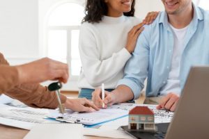 Smiley Couple Signing Contract For New House 300x200